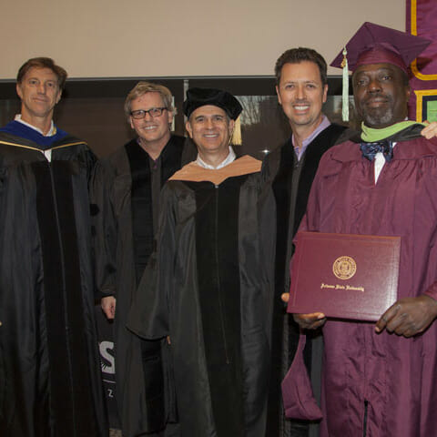 Graduation photo of Yemi Adelwole (right) and four faculty members